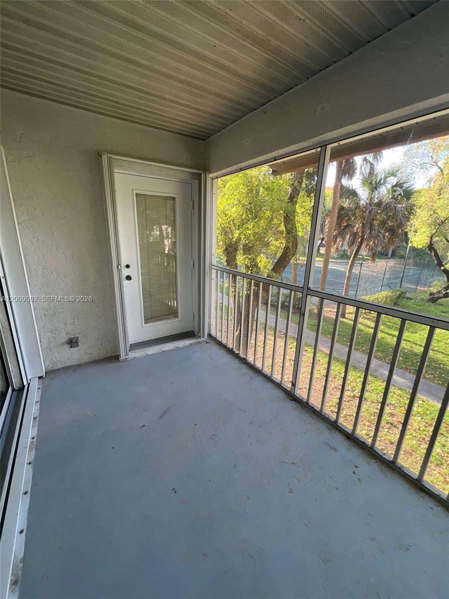 9203 Southwest 138th Place, Unit 9203 Miami, FL 33186 - Photo 20 of 22 a view of a hallway with a porch