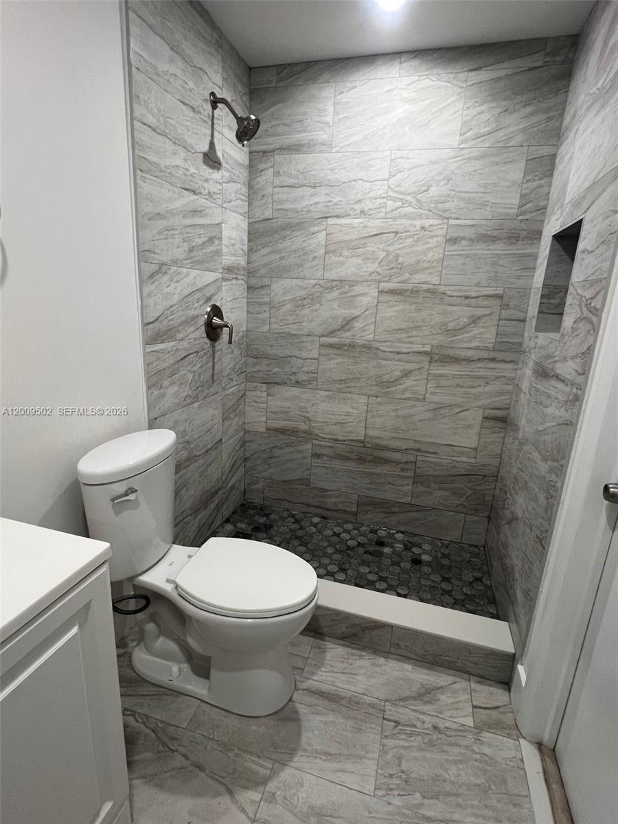 9203 Southwest 138th Place, Unit 9203 Miami, FL 33186 - Photo 21 of 22 a bathroom with a toilet and a shower