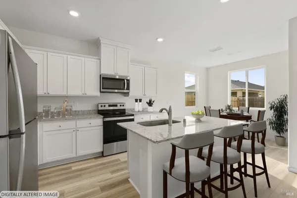 a kitchen with granite countertop white cabinets and stainless steel appliances