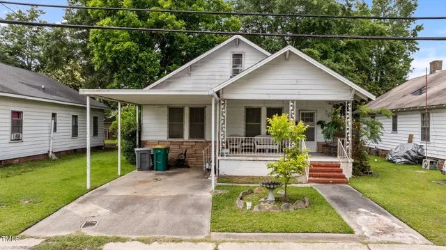 a view of a house with a yard patio and small yard