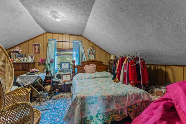 a bedroom with a bed and a painting on the wall