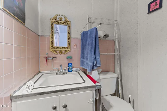 a bathroom with a granite countertop toilet sink and mirror
