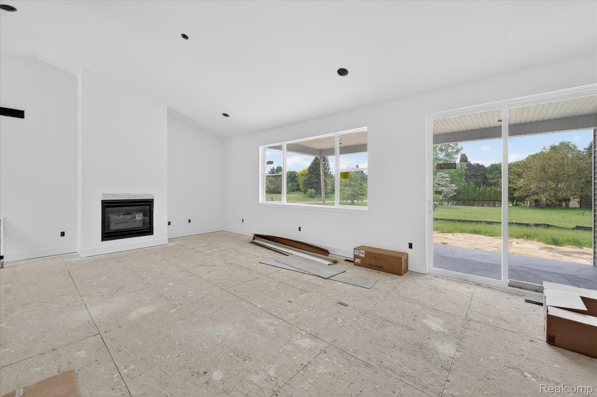 3297 Oak Grove Road Howell, MI 48855 - Photo 4 of 40 Bright and open great room with vaulted ceilings, fireplace, and large windows overlooking the backyard.
