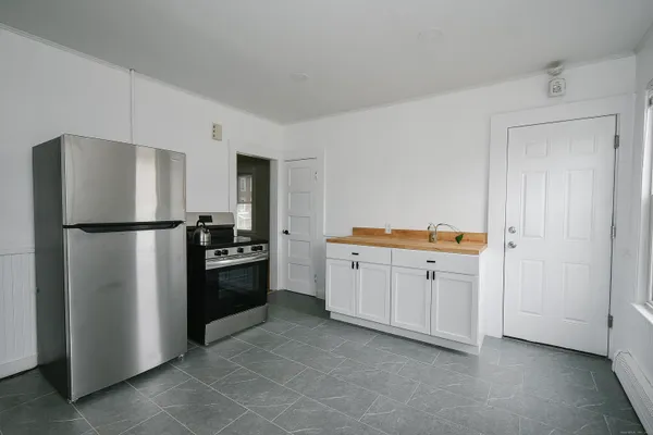 a kitchen with a refrigerator stove and white cabinets