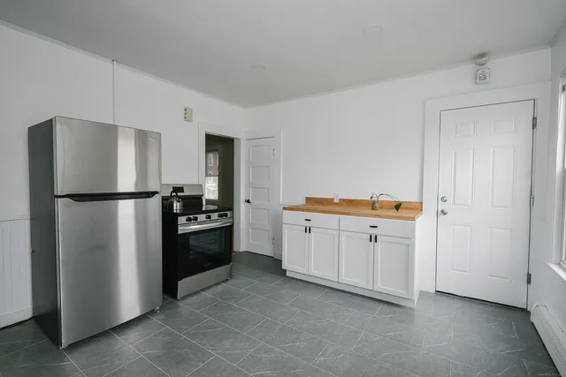a kitchen with a refrigerator stove and white cabinets