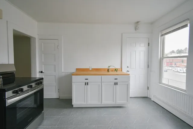a kitchen with cabinets appliances and a window