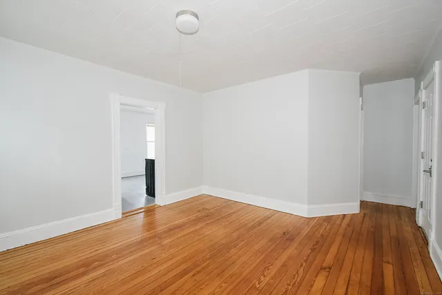 a view of empty room with wooden floor