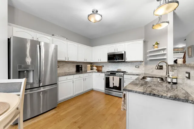 a kitchen with granite countertop a refrigerator stove and microwave