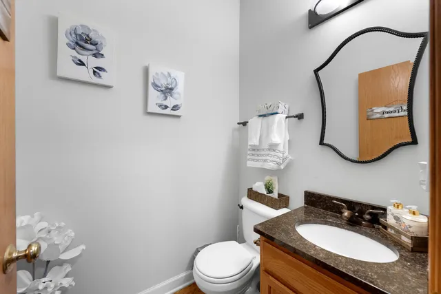 a bathroom with a granite countertop toilet sink and mirror