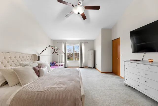 a bed room with bed and a flat tv screen on dresser