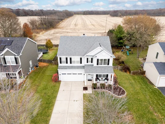 a aerial view of a house with swimming pool next to a big yard