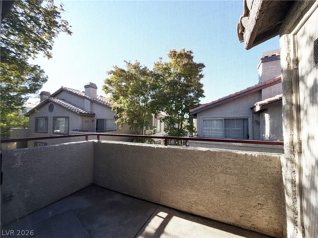 4955 South Lindell Road, Unit 203 Las Vegas, NV 89118 - Photo 29 of 31 Step out onto this balcony for serene views of mature trees and neighboring tile-roofed residences.