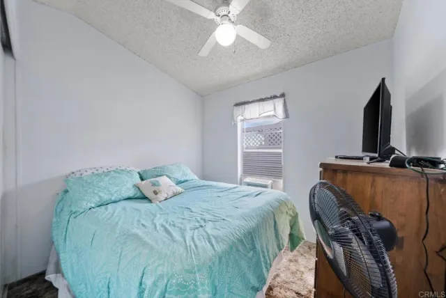 a bedroom with a bed and dresser with mirror