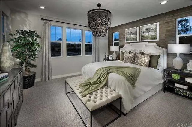 a spacious bedroom with a bed and a chandelier