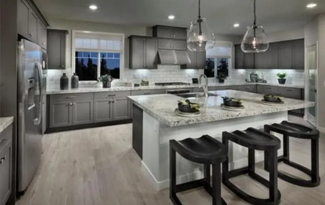 a kitchen with kitchen island granite countertop a sink and refrigerator