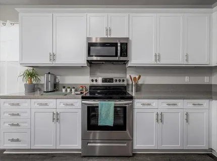 a kitchen with white cabinets and stainless steel appliances