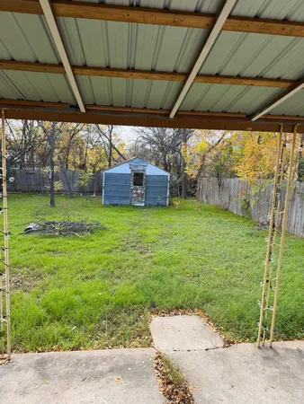 a view of a backyard with table and chairs under an umbrella