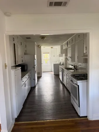 a large kitchen with a stove and a refrigerator