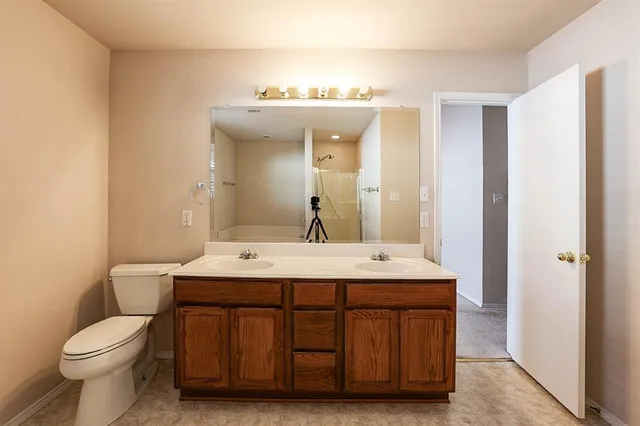 a bathroom with a sink a toilet and a mirror