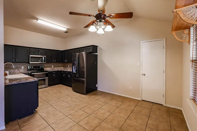 a kitchen with stainless steel appliances granite countertop a refrigerator and a sink