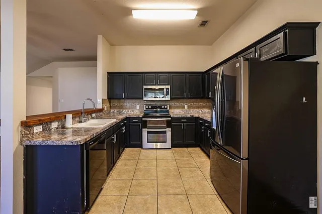 a kitchen with granite countertop stainless steel appliances and wooden cabinets