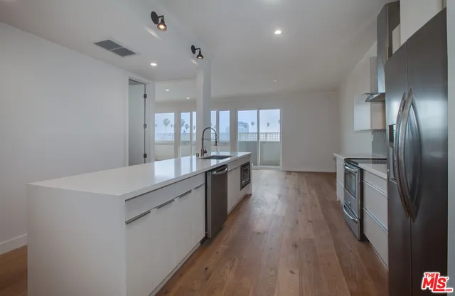a kitchen with stainless steel appliances a sink stove and refrigerator