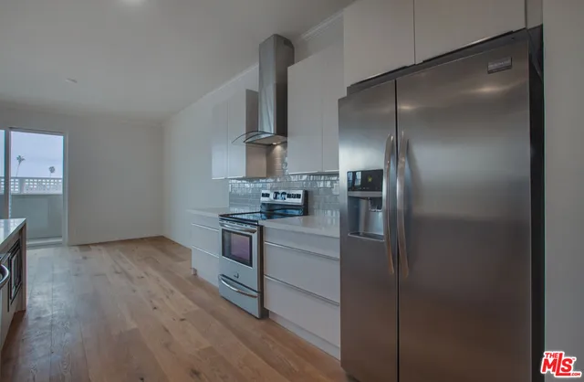 a kitchen with stainless steel appliances a refrigerator and a stove top oven