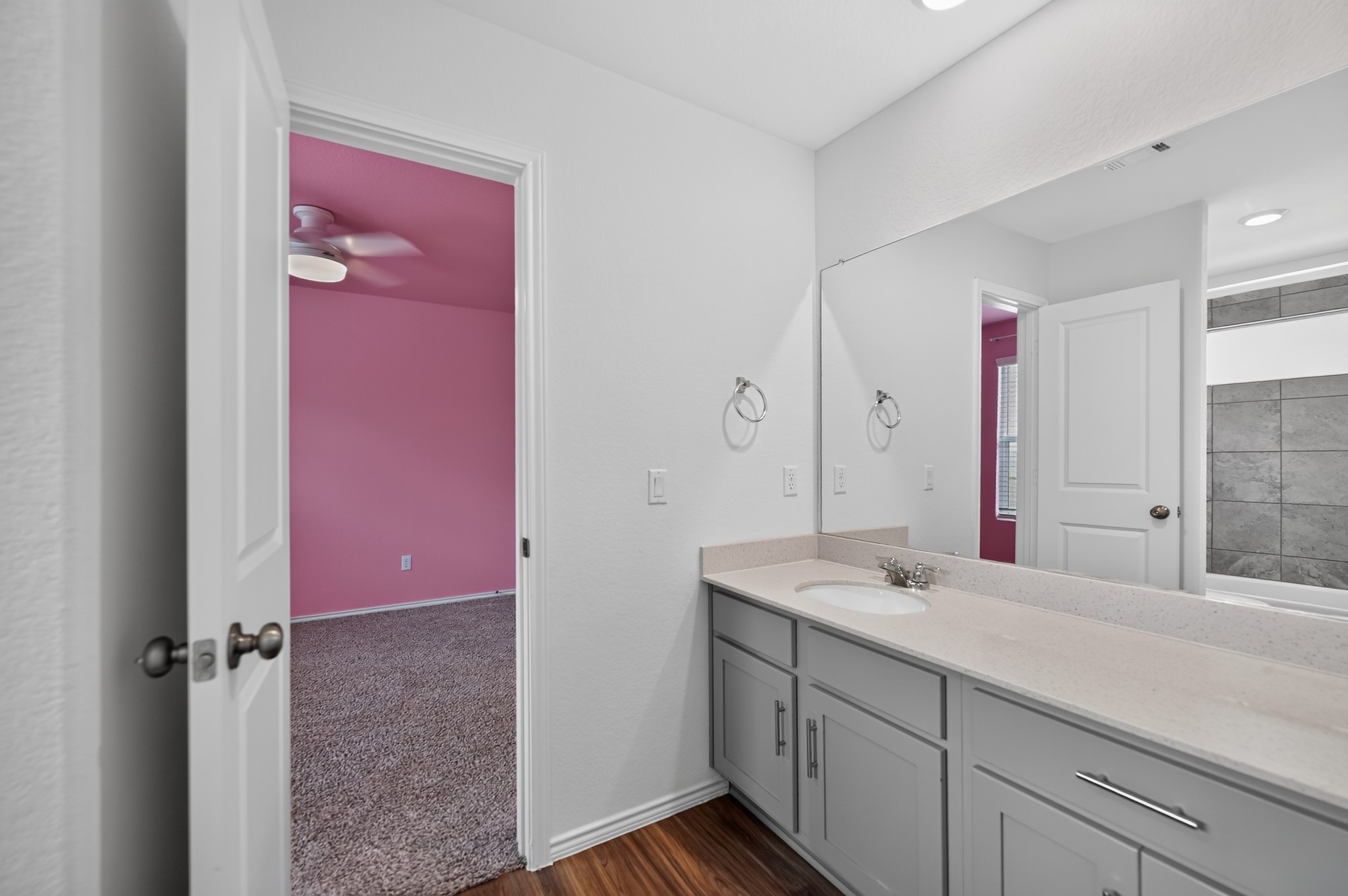 128 Konik Road Georgetown, TX 78626 - Photo 20 of 34 A well-appointed bathroom vanity with ample counter space and a glimpse into a vibrant bedroom.