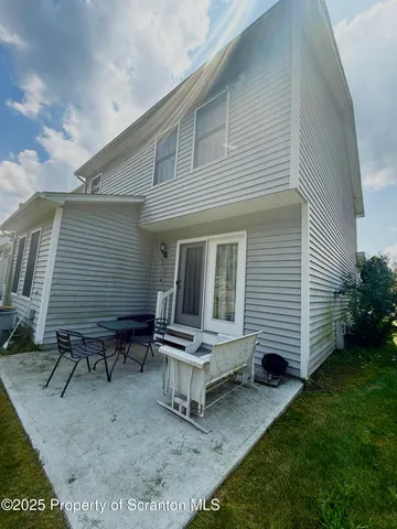 a backyard of a house with table and chairs