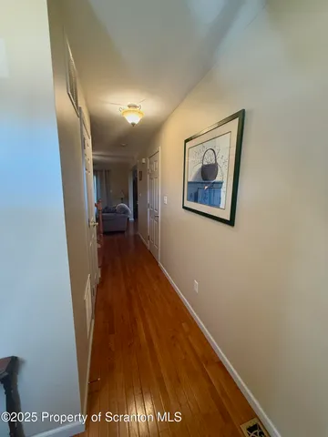 a view of hallway with stairs and wooden floor