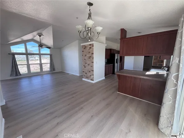 a view of a dining room with furniture a chandelier and wooden floor