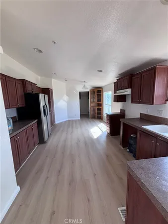 a kitchen with stainless steel appliances wooden floors and wooden cabinets