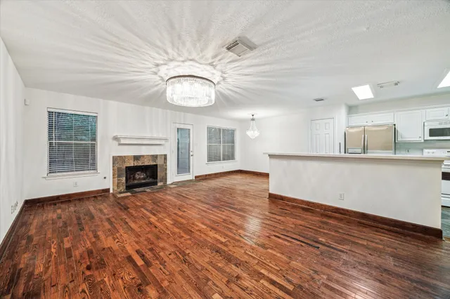 a view of empty room with wooden floor and fireplace