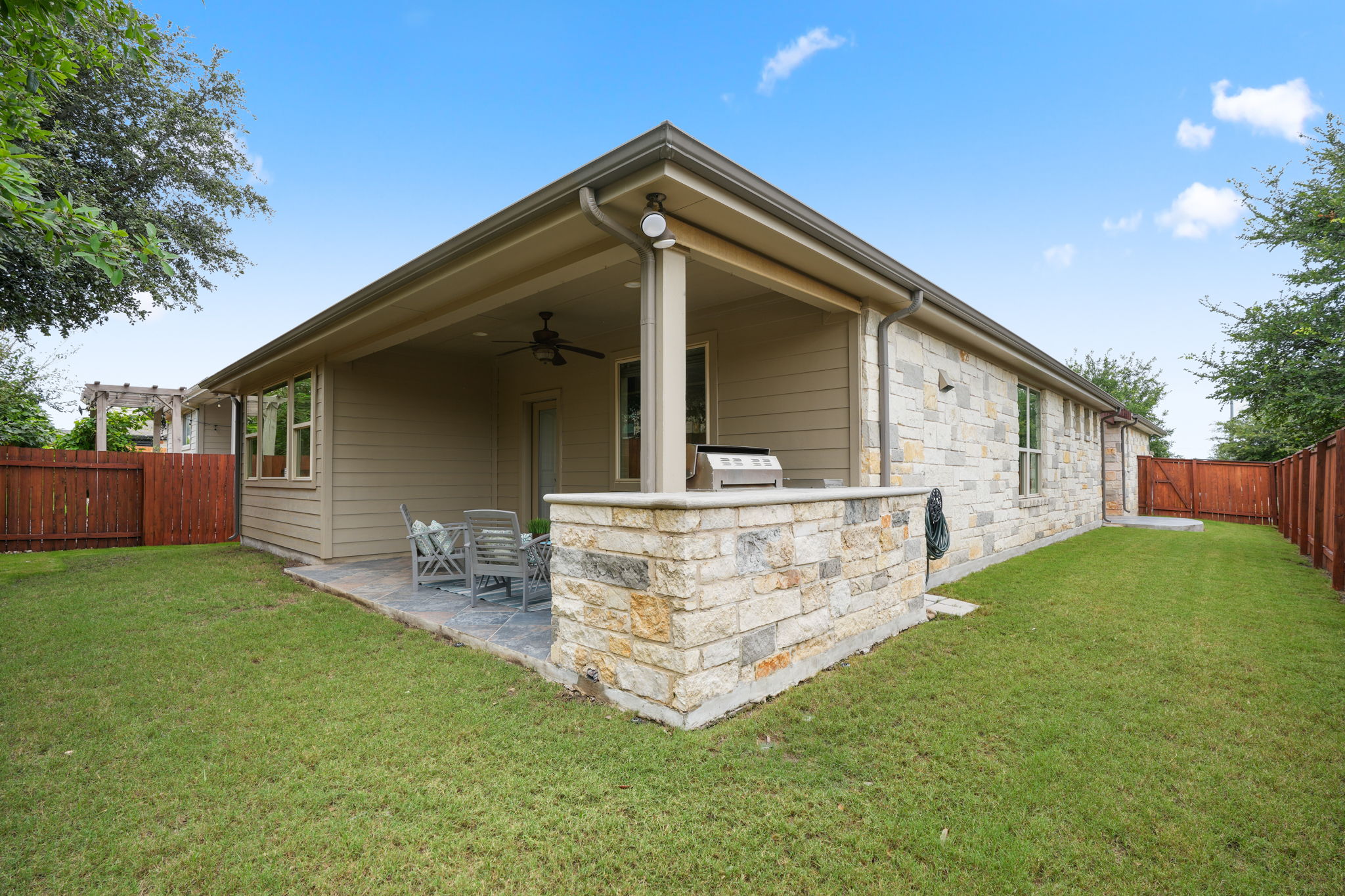 440 Cherokee Rose Circle Georgetown, TX 78626 - Photo 32 of 39 An inviting covered patio featuring an outdoor kitchen provides an ideal setting for al fresco dining and entertaining.