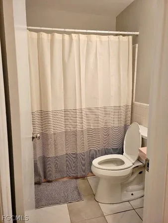 a white toilet sitting next to a shower curtain