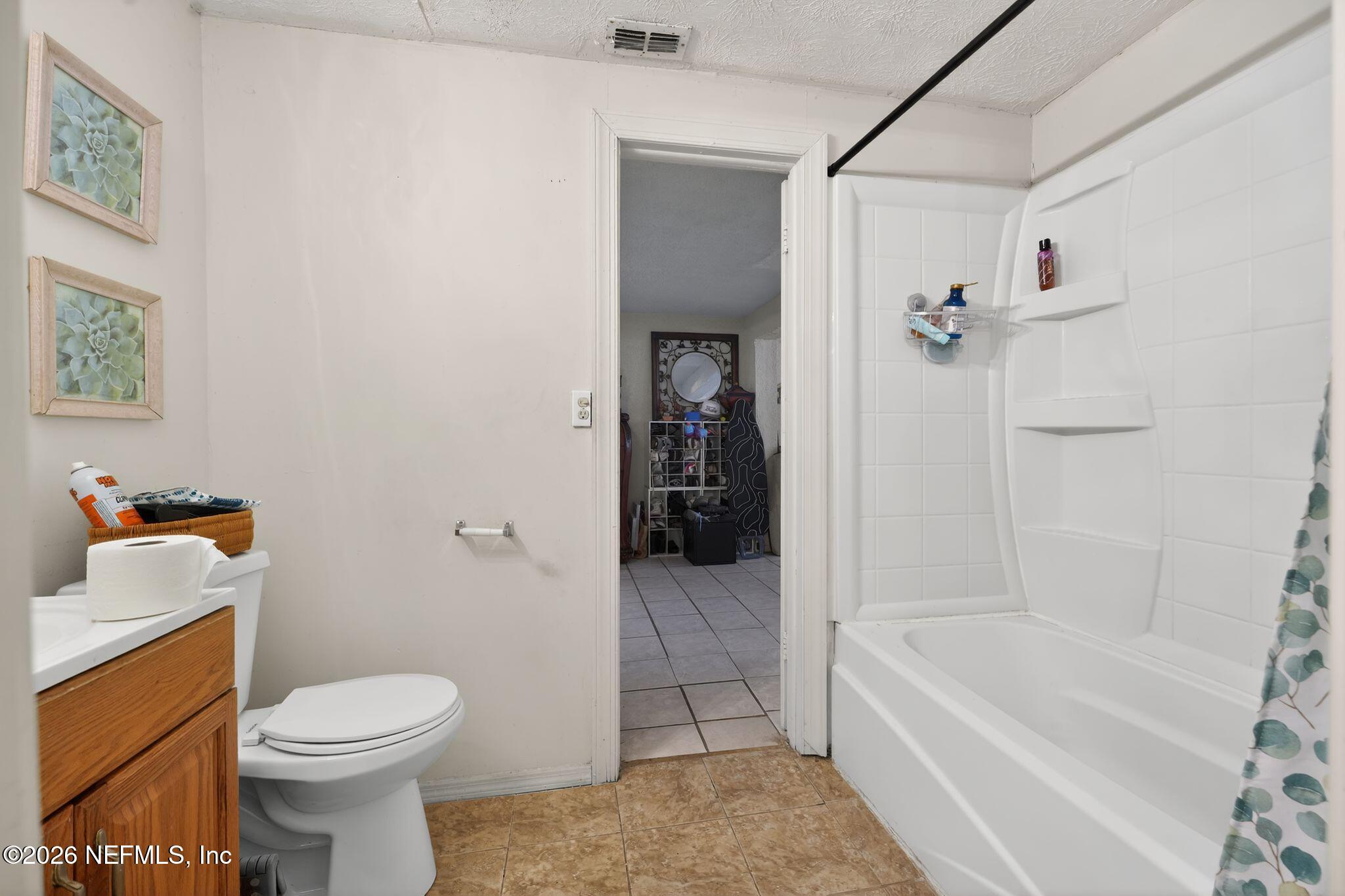 5211 Arrowsmith Road Jacksonville, FL 32208 - Photo 16 of 24 a bathroom with a bath tub a toilet and a shower