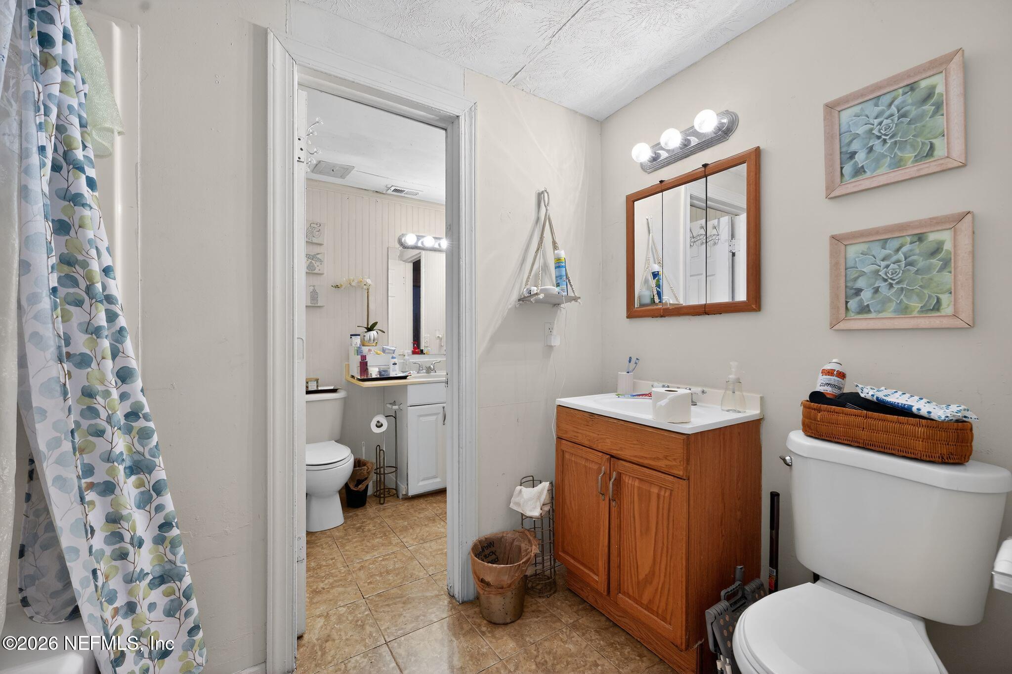 5211 Arrowsmith Road Jacksonville, FL 32208 - Photo 17 of 24 a bathroom with a toilet a sink and a mirror
