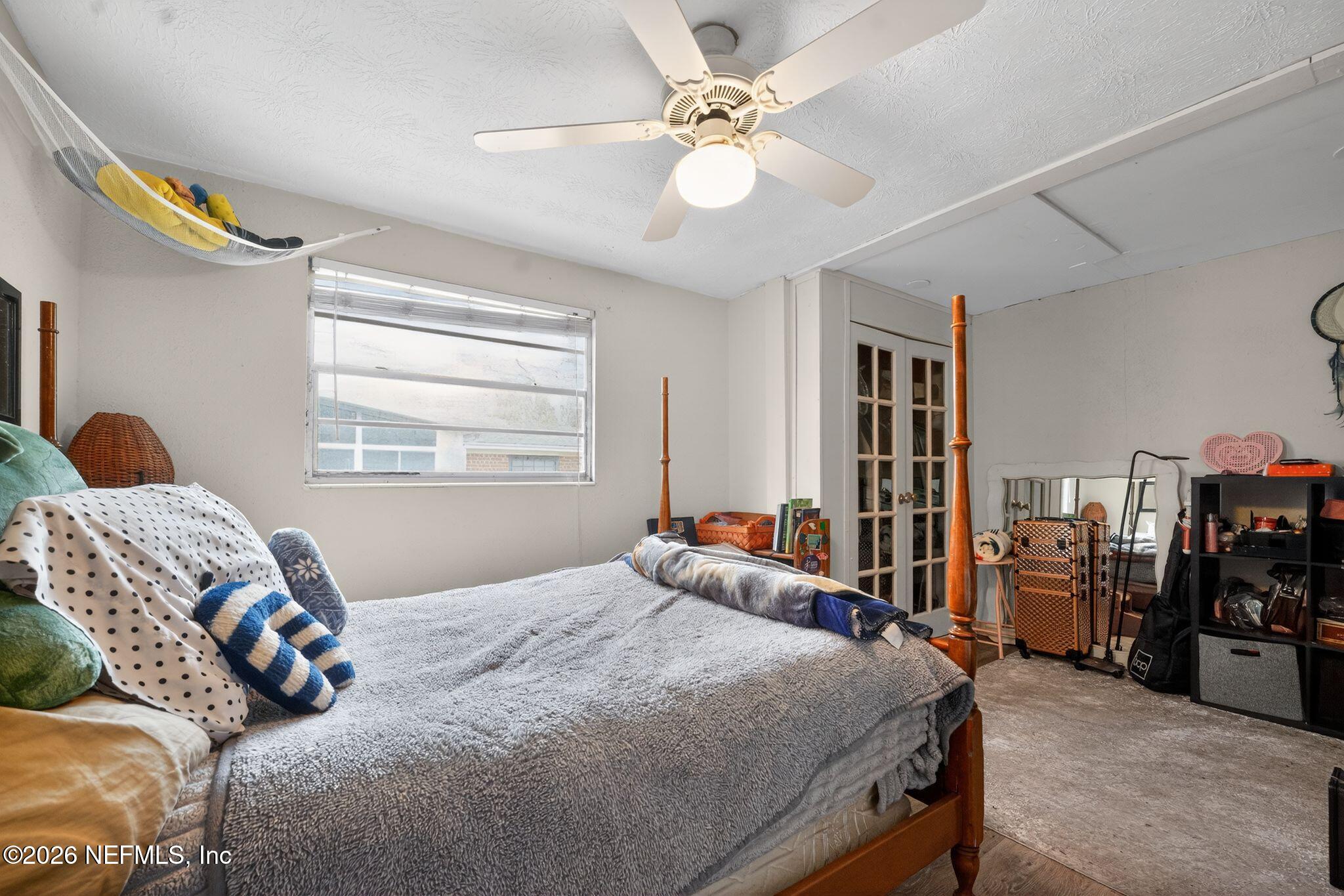 5211 Arrowsmith Road Jacksonville, FL 32208 - Photo 18 of 24 a bedroom with a bed and a chandelier