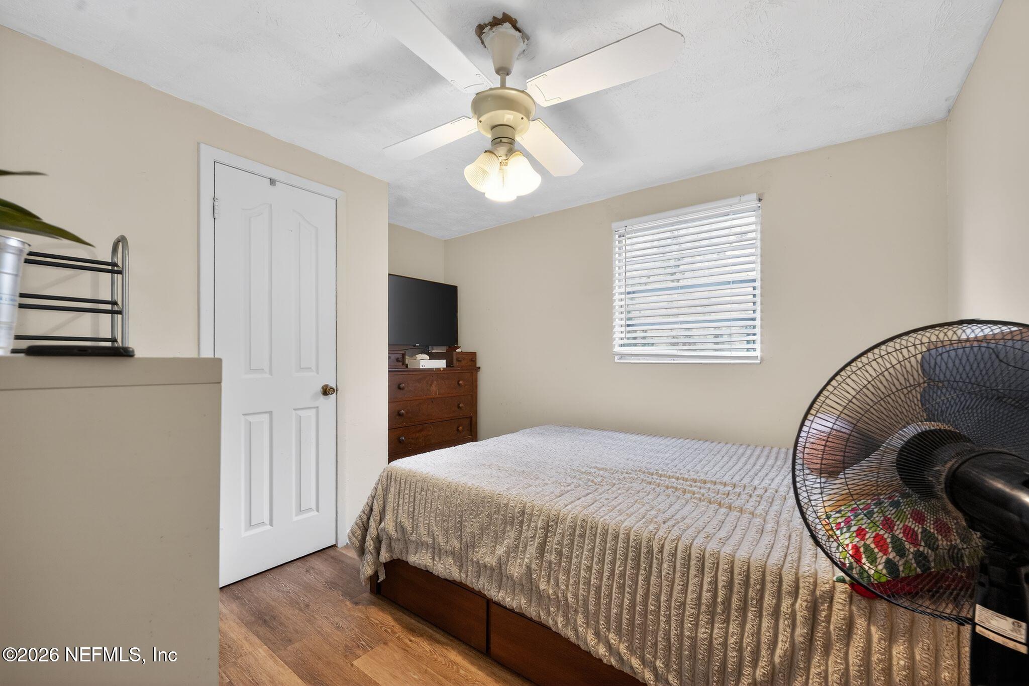 5211 Arrowsmith Road Jacksonville, FL 32208 - Photo 19 of 24 a bedroom with a bed and a chandelier