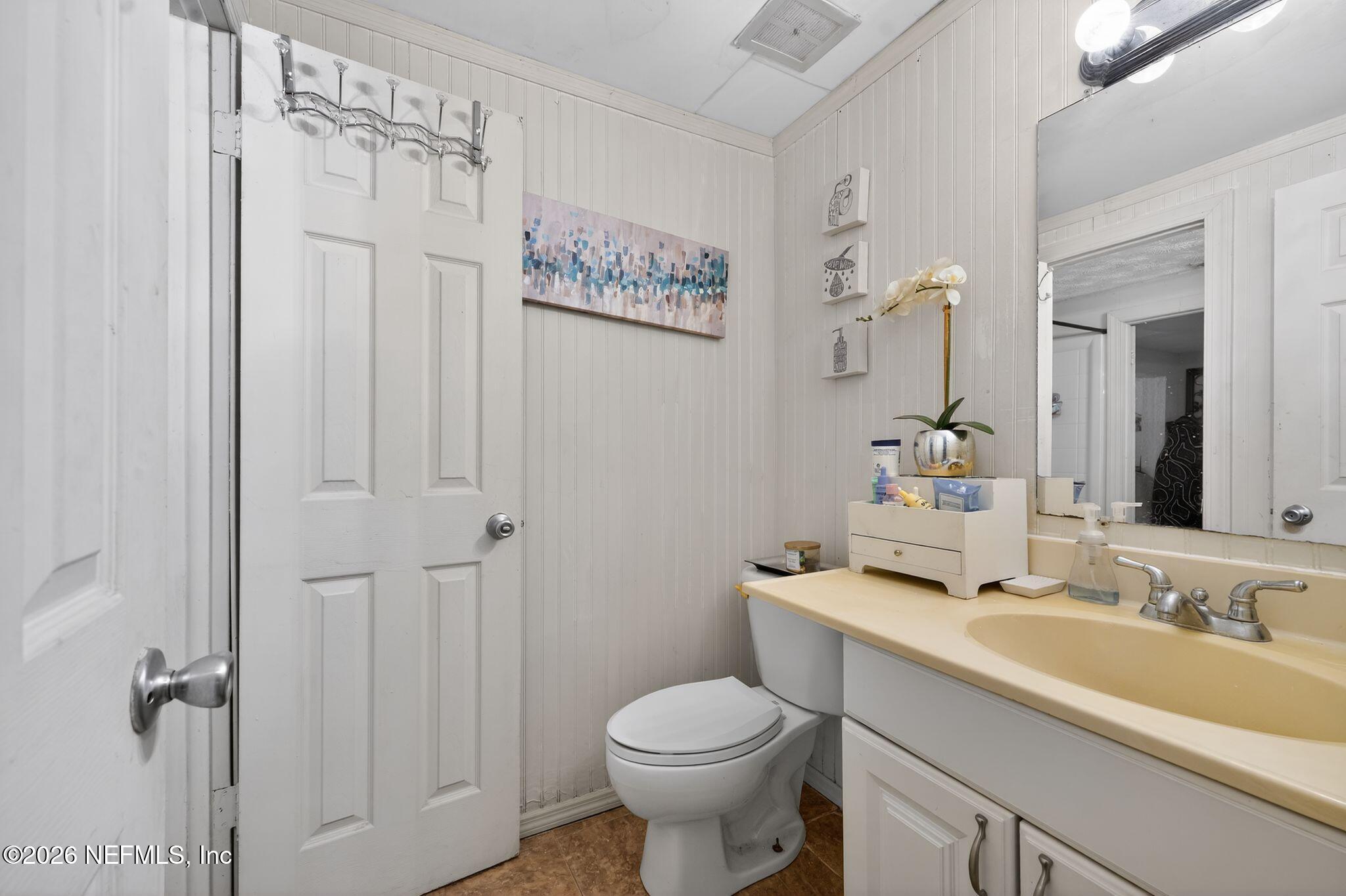 5211 Arrowsmith Road Jacksonville, FL 32208 - Photo 20 of 24 a bathroom with a toilet sink and mirror