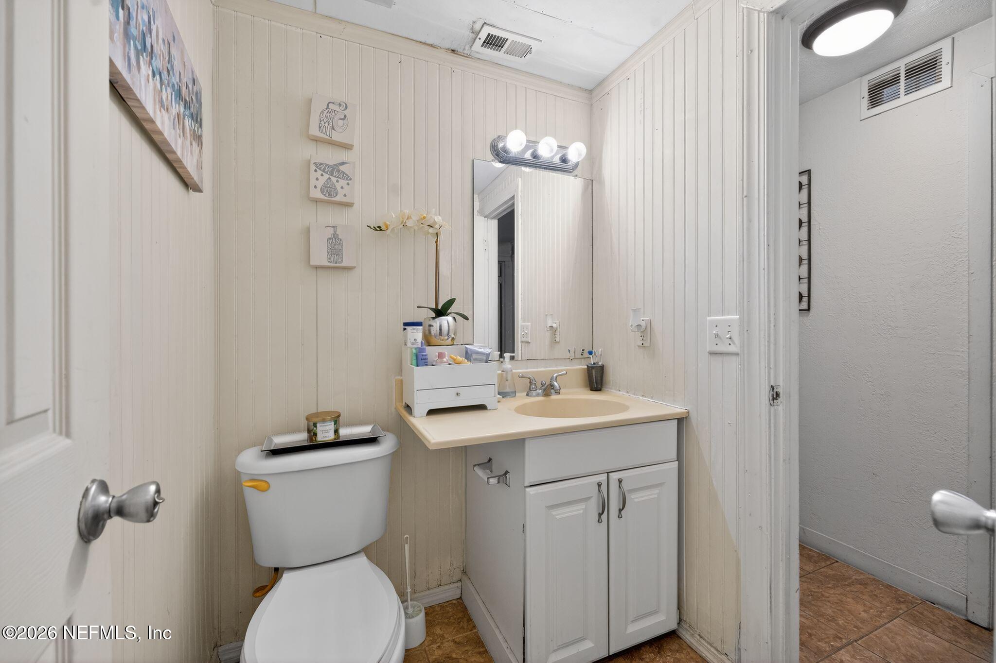5211 Arrowsmith Road Jacksonville, FL 32208 - Photo 21 of 24 a bathroom with a toilet sink and mirror