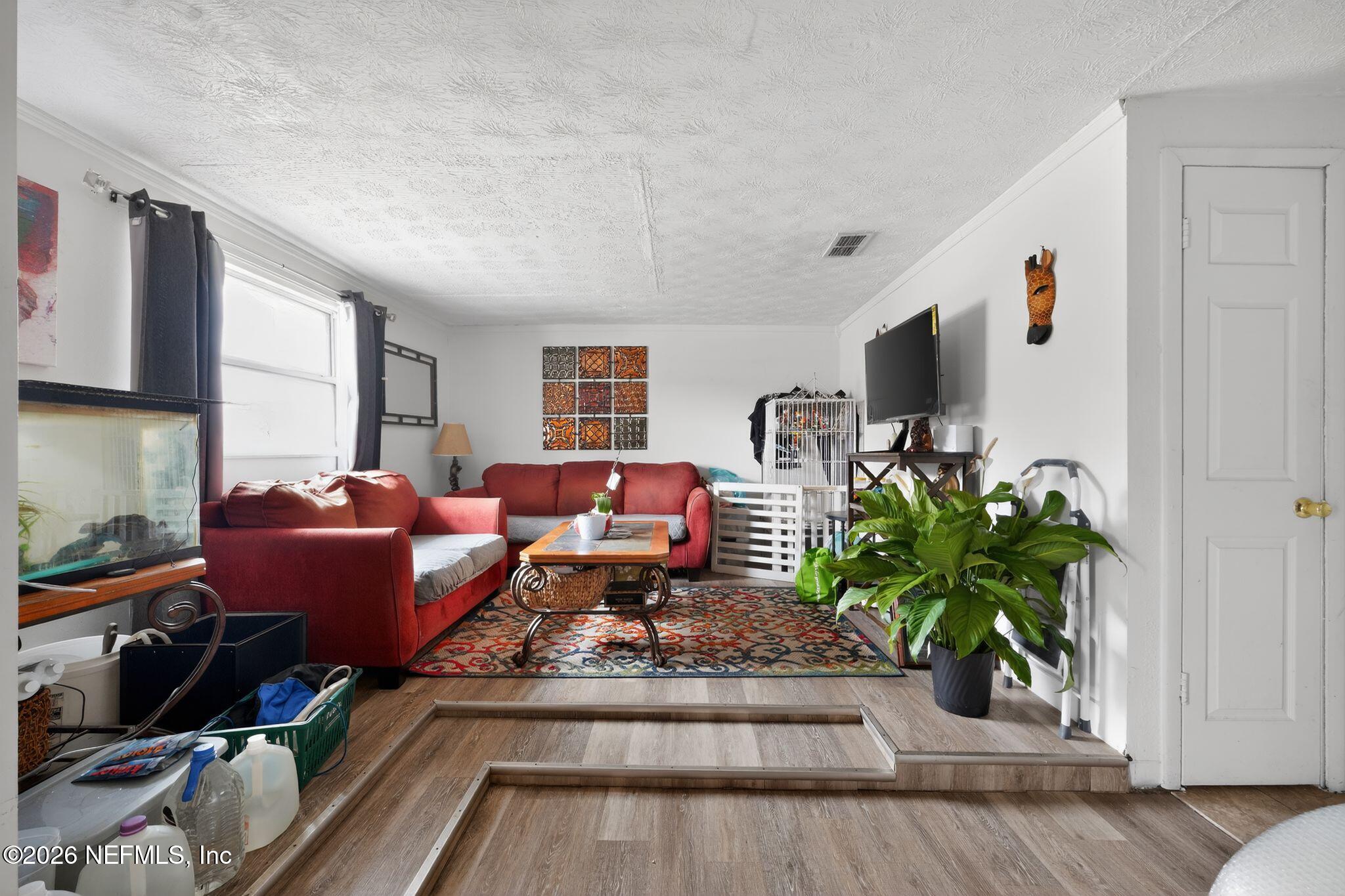 5211 Arrowsmith Road Jacksonville, FL 32208 - Photo 3 of 24 a living room with furniture and a flat screen tv