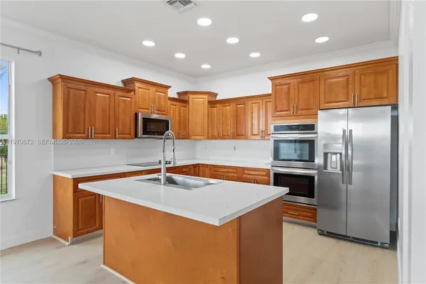 a kitchen with stainless steel appliances granite countertop a sink and a refrigerator