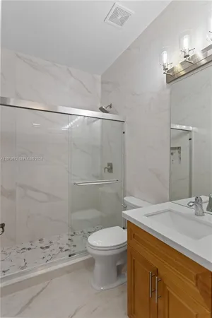 a bathroom with a sink a toilet and shower