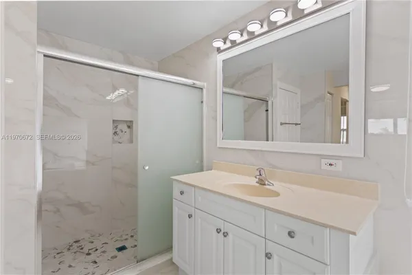 a bathroom with a sink a light fixture and a mirror