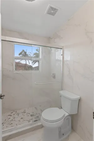 a white toilet sitting next to a bathroom sink