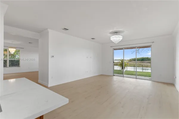 an empty room with floor to ceiling window and an outdoor view