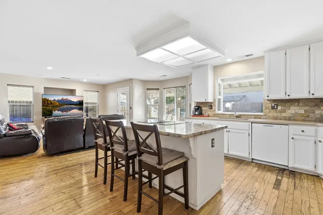 a kitchen with kitchen island granite countertop a sink appliances and cabinets