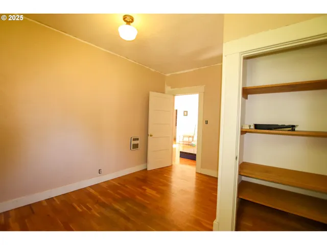 a view of a hallway with wooden floor and furniture