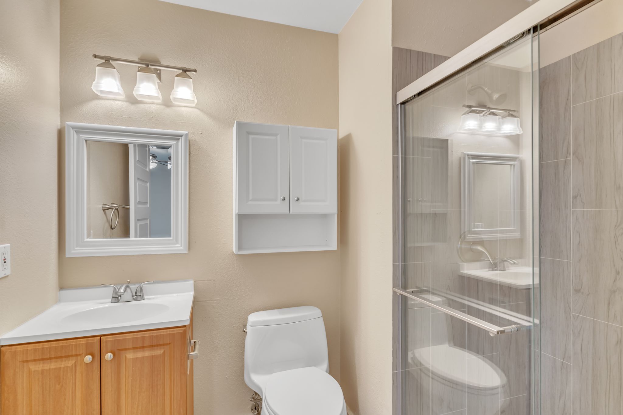 3214 Clawson Road, Unit A Austin, TX 78704 - Photo 13 of 26 A well-appointed bathroom features a glass-enclosed shower alongside a vanity with wood cabinetry.